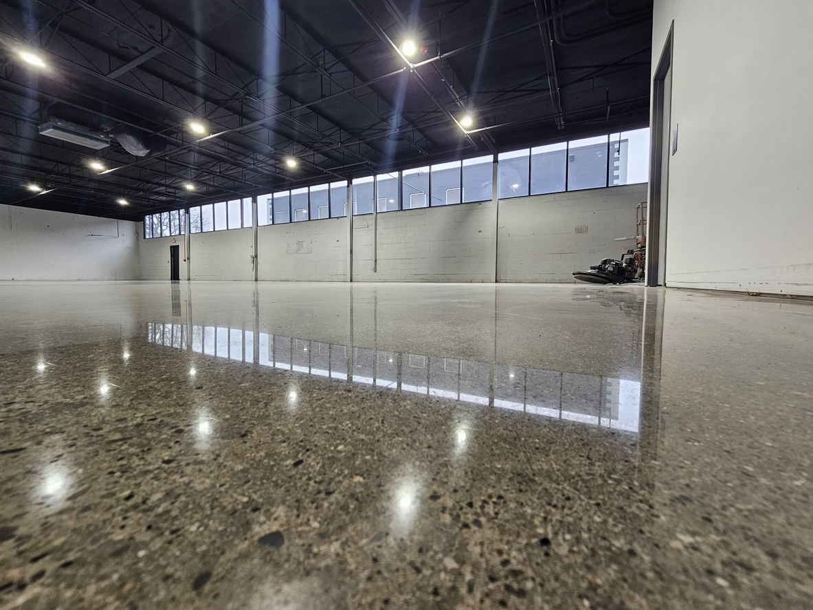 Elite Epoxy Floors of Austin team performing diamond grinding surface preparation before epoxy floor coating installation